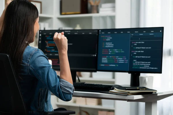 Young Asian IT developer creating raising fist up with successful information on pc with coding program information data application, wearing jeans shirt surround safety analysis screen. Stratagem.