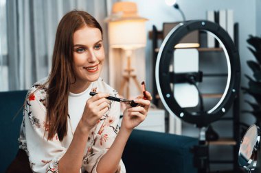 Kadın Etkilenen Vlog video görüntülerini sosyal medya ya da blog 'da en üst düzeyde yayınlıyor. Kozmetik stüdyosu ışıklandırmalı mutlu genç kız çevrimiçi pazarlama oturumu yayını için..