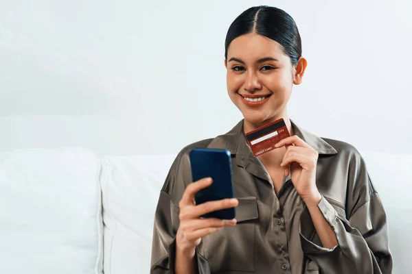 Young happy Asian woman buy product by online shopping at home while ordering items from the internet with credit card online payment protected by uttermost cyber security from online store platform