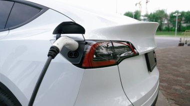 EV elektrikli araç EV şarj istasyonu ulusal park veya açık hava orman manzaralı. Çevre dostu EV arabalarla yaz ormanlarında doğal koruma. Yükselt