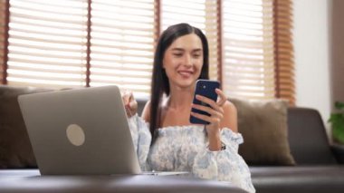 Genç bir kadın internet bankacılığı için kredi kartıyla dizüstü bilgisayar kullanıyor. Evinde online ödeme kapısı ile E ticareti yapıyor. Banka kartıyla modern ve kullanışlı online satın alma. Blithe