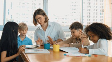 Masada masal kitabı ve renkli kitapla otururken çeşitli öğrencilere hikaye anlatan profesyonel beyaz bir öğretmen. Eğitmenden renkli resim alırken akıllı öğrenci dinlemeyi öğrenir. Etkinlik.