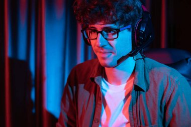 Stresli genç oyun flaması takımı, Esport ile çevrimiçi olarak bilgisayar üzerinde daha sert oyun seviyesine odaklanmış ve neon aydınlatma odasında strateji planı uygulamak için sürpriz yüz ifadesiyle kazanmayı denemiştir. Toplayıcı.