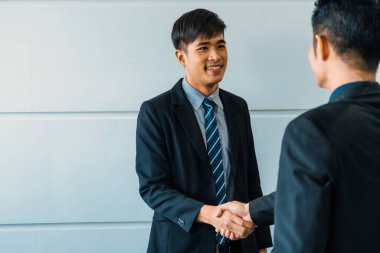 İş adamları konsepti kabul ediyor. Asyalı iş adamı ofis toplantı odasında başka bir iş adamıyla tokalaşıyor. uds