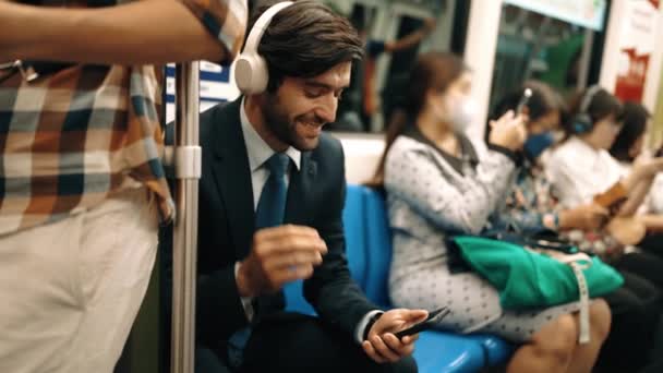 Gülümseyen Yakışıklı Yatırımcı Trende Otururken Rahatlatıcı Müzik Dinliyor Profesyonel Adamı — Stok video