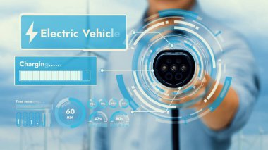 Kameranın önündeki EV şarj aletine odaklan. Bulanık yeşil elektrik jeneratöründe akıllı pil durum hologramını göster. Karbondioksit salınımını azaltmak için temiz enerji kullanan elektrikli araba şarjı.