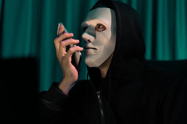 White criminal anonymous mask calling to IT owner to threaten ransom with big database, installing coding password encryption by programming hack, trying to make insecure thorough privacy. Pecuniary.