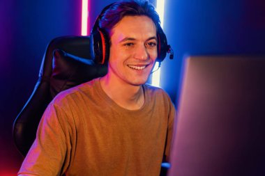 Kazanmak için çevrimiçi oyun oynayan akıllı flama makinesinin sunucu kanalı, neon ışıklı odada seçilen takım yarışması için izleyicilerle birlikte canlı yayında canlı yayında kulaklık takıyor. Bireysel.