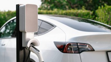 Elektrikli araç portuna bağlı EV şarj prizi kolu şarj istasyonundan şarj oluyor. Modern tasarlanmış EV araba ve daha iyi bir gelecek konsepti için temiz enerji sürdürülebilirliği. Eşzamanlama