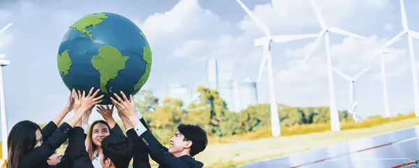 アジアのビジネスの人々が開催する大きな地球地球のコンセプトは クリーンな持続可能で再生可能なエネルギーと風力タービンで環境への意識を促進するチームです ガイヤー イングランド — ストック写真