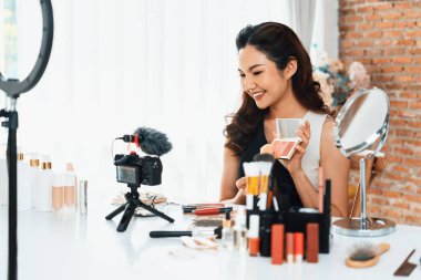 Asyalı Kadın Etkilenen Vlog 'ta canlı yayın yapan videolar sosyal medya ya da blog' un çoğunu oluşturuyor. Kozmetik stüdyosu ışıklandırmalı mutlu genç kız çevrimiçi pazarlama oturumu yayını için.