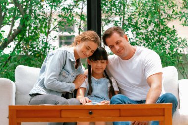 Ebeveynler kızlarını sevgi dolu kucaklaşmalarla rahatlatıyorlar, onun güvende ve korkudan korunmasına yardım ediyorlar, başını omzuna yaslıyorlar. Mutlu aile sevgisi ve çocuk bakımı konsepti. Eşzamanlama