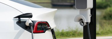 Green City Park 'taki otoparkta EV elektrikli araba şarj bataryası. Sürdürülebilir çevre dostu kentsel yolculuklar için yenilenebilir otomobil için alternatif temiz enerji teknolojisi. Panorama Uygulaması