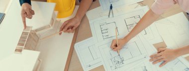 Yetenekli mimar mühendis ekibi ve iç mimar toplantısı ev inşaatını tasarım ve mimari ekipmanlarla birlikte sunar. Dağılın. Eline odaklan. Üst Manzara. Filizlenen.