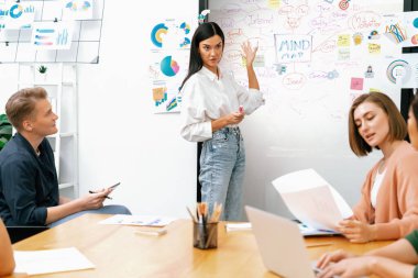 Genç ve güzel lider pazarlama stratejisini sunarken, uzman yatırımcı ve proje yöneticisi de yeni başlayan iş toplantısında iş performansını analiz etmeye çalışıyor. Çok ırklı bir grup. Tertemiz..