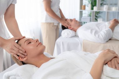 Kafkasyalı çift stres önleyici kafa masajının keyfini çıkarıyor ve lüks otellerde ya da otel spa salonlarında gündüz kaplıcalarında yüz güzelliği eğlencelerini şımartıyor. Sessiz.