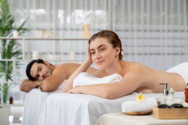 Lüks spa salonlarında sıcak mum ışığında cilt bakımı gören mutlu çift müşterisi. Sağlık kaplıcasında güzellik tedavisiyle tuz temizliği. Sessiz.