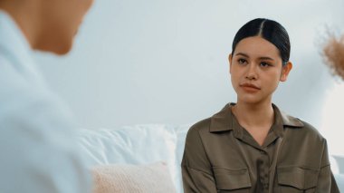 Psikologla ruh sağlığı terapisi gören üzgün travma sonrası stres bozukluğu olan bir kadın. Yaşam sonrası depresyon veya keder. Hayal kırıklığına uğramış genç bir kadın klinikteki duygular hakkında Vivancy psikoloğuyla konuşuyor.