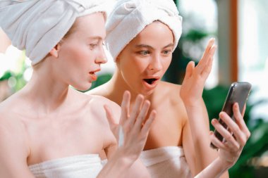 Beyaz havluyla güzel ciltli bir çift güzel kadın açık havada barışçıl doğal çevreyle çevrili bir şekilde fotoğraf çekiyorlar. Güzellik ve sağlıklı spa konsepti. Huzur.