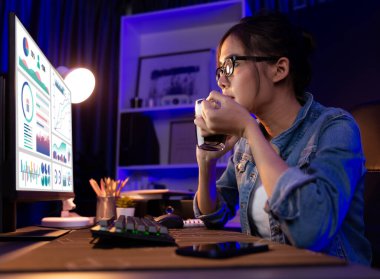 Sunucu kanalı Asyalı etkileyicisi, sosyal medyada kulaklık takarak iş grafikleri ekranında dinleyicileri selamlıyor ve Neon Modern Stüdyoları 'nda internet üzerinden koçluk yapıyor. Taktik.