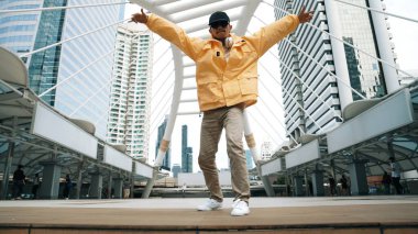 Asyalı hippi break dans çalışmasının düşük açılı kamerası ya da kulaklık takarken break dans performansı. Serbest dans, break dans, sokak dansı. Neşeli bir ruh hali. Açık hava sporu 2024. Yumuşak bir şekilde..