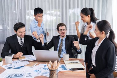 Kutlama jesti ve başarılı takım çalışması yapan bir grup mutlu iş adamı. Çeşitli yarış bürosu çalışanları şirket ofisinde pazarlama planlamasında ilerleme kaydettikten sonra kutlama yapıyorlar. Çok titiz.