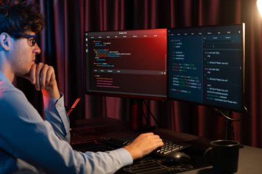 Uygulama pc ekranları ile çevrili çevrimiçi yazılım geliştirme bilgilerini yoğunlaştıran IT geliştiricisi, neon modern ofis evindeki web sitesinde yazılım için program yaratıyor. Toplayıcı.