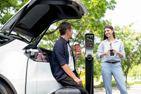 Lovely Young Couple Drinking Coffee While Recharging Battery Electric Car — Stock Photo, Image