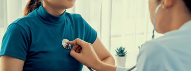 Hasta klinikte ya da hastane ofisinde doktor randevusuna gidiyor. Hastaların nabzını steteskopla kontrol ederken, doktor semptomları muayene ediyor ve teşhis ediyor. Panorama Katı