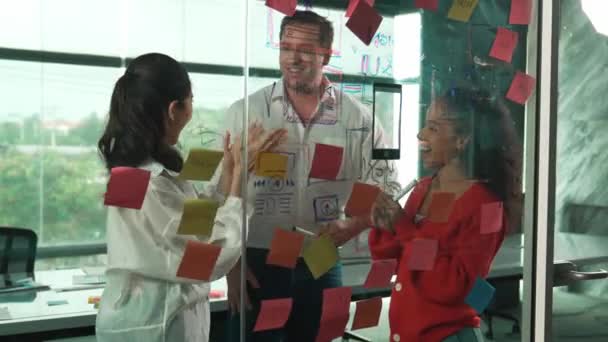 快乐的专业商业团队集思广益营销理念 使用彩色粘贴贴纸在玻璃墙上分享创意 由不同的商业团队组成的小组讨论策略 机械手 — 图库视频影像