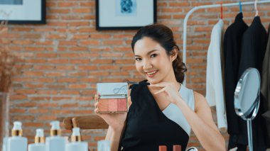 Kadın nüfuzlu kişi canlı yayın yapan video görüntülerini sosyal medya ya da blog üzerinden gözden geçiriyor. Kozmetik stüdyosu ışıklandırmalı mutlu genç kız çevrimiçi pazarlama oturumu yayını için..