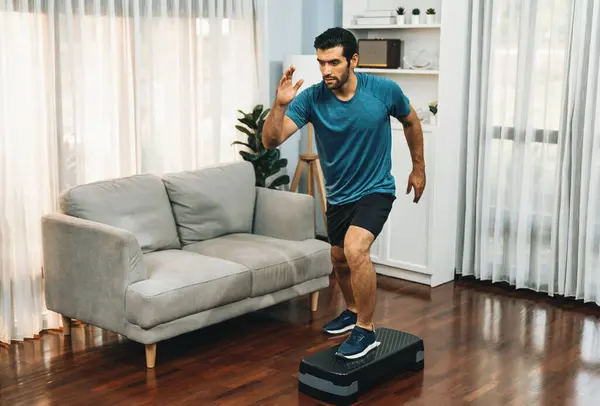 Athletic and sporty man running posture at home body workout exercise session for fit physique and healthy sport lifestyle at home. Gaiety home exercise workout training.