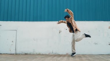 İspanyol komedi koreografı hip hop tarzında dans ediyor. Genç mutlu break dansçı B-boy dansı yapıyor. Sokak dansı yapan komik adamın hareket çekimi. Açık hava sporu 2024. Modern dans. hiphop.