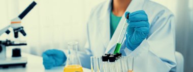 Laboratuvar araştırmacısı laboratuvar tüpünde kimyasal sıvı kullanarak yeni ilaç ya da tedavi geliştirir. Laboratuvar ekipmanları ile bilimsel uzmanlık ile sağlık hizmetlerinin teknolojik gelişimi. Panorama Katı