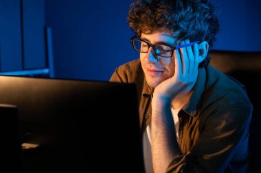 Stresli yaratıcı yönetici yeni sunumla tasarım araması yaparken ev ofisteki dizüstü bilgisayarlı ekranda gece vakti neon lambalı bir odada e-posta göndermeyi bekliyor. Toplayıcı.