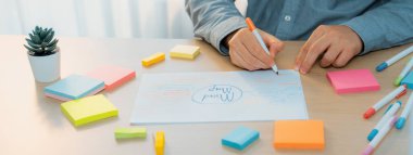 Yetenekli iş adamları zihin haritaları kullanarak pazarlama fikirleri üretiyor. Başarılı erkek girişim lideri masaya yapış yapış notlar serpiştirerek finansal plan hazırlıyor. - Yakın çekim. Eline odaklan. Değişik..