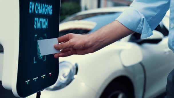 商人在收费站支付电动车生态友好型可持续能源扫描信用卡 在收费点为他的充电式电动车充电 仔细阅读 — 图库视频影像