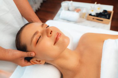 Kafkasyalı kadın stres önleyici kafa masajından ve lüks tatil beldesi ya da otel spa salonundaki modern ışık ortamında yüz güzelliği eğlencelerini şımartmaktan hoşlanıyor. Sessiz.