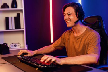 Kazanmak için çevrimiçi oyun oynayan akıllı flama makinesinin sunucu kanalı, neon ışıklı odada seçilen takım yarışması için izleyicilerle birlikte canlı yayında canlı yayında kulaklık takıyor. Bireysel.