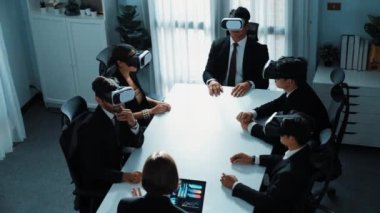 Dizüstü bilgisayarda çalışan proje yöneticisinin üst görüntüsü ve VR cam kulaklık kullanarak iş adamlarına veri analizi gönderilmesi. Profesyonel pazarlama ekibi meta veriye ya da sanal dünya programına girer. Müdürlük.