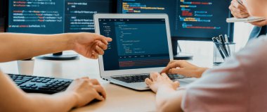 Bilgisayar ekranında program kodu gösterilirken iki akıllı kooperatif bilgisayar mühendisi program kodunu çözmek için takım çalışması yapıyor. Laptop, web geliştirme, programcı, Java betiği. Filizlenen.