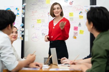 Profesyonel çekici kadın lider, modern iş toplantı odasında beyin fırtınası zihin haritalama istatistikleri ve renkli yapışkan notlar kullanarak yaratıcı pazarlama planını sunuyor. Tertemiz..