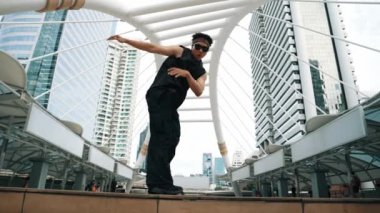 Profesyonel sokak dansçısı B-boy dansının alçak açılı kamerası. Genç ve çekici hippi hip-hop müziğine taşınırken şehir merkezinde break dans gösterisi yapıyor. Açık hava sporu 2024. Yumuşak bir şekilde..