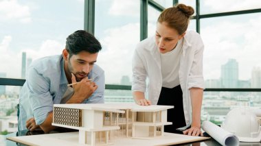 Kooperatif mimar mühendis ekibi kalem kullanarak ev modelini ölçmek için birlikte çalışıyor. Başarılı bir Kafkas iç mimari tasarım ekibi mimari model yapısını inceliyor. Tasarım. İzleme