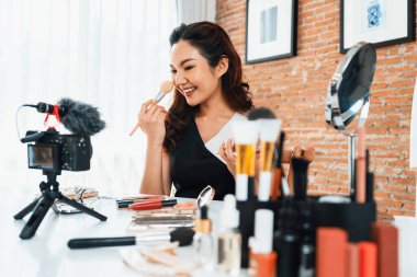Kadın Etkilenen Vlog video görüntülerini canlı olarak çekiyor. Makyajın çoğu sosyal medya ya da blog 'u anlatıyor. Kozmetik stüdyosu ışıklandırmalı mutlu genç kız çevrimiçi pazarlama oturumu yayını için..