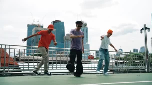 一群熟练的霹雳舞者在屋顶上与城市或摩天大楼的景观一起表演嘻哈脚步声 帅气的嬉皮士队在公共场合表演时髦的音乐 2024年户外运动 神气活现 — 图库视频影像