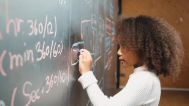 Genç Afrikalı bir kızın karatahtaya mühendislik komut ya da kod yazması. BTMM teknoloji sınıfında kodlama ve programlama sistemi kullanarak bir proje planlama konusunda yetenekli bir öğrenci. Etkinlik.