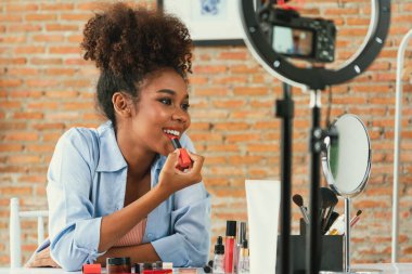 Kadın nüfuzlu kişi canlı yayında video görüntülerini çekiyor. Makyaj çok önemli sosyal medya ya da blog. Kozmetik stüdyosu ışıklandırmalı mutlu genç kız çevrimiçi pazarlama oturumu yayını için..