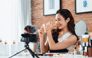Kadın Etkilenen Vlog video görüntülerini canlı olarak çekiyor. Makyajın çoğu sosyal medya ya da blog 'u anlatıyor. Kozmetik stüdyosu ışıklandırmalı mutlu genç kız çevrimiçi pazarlama oturumu yayını için..
