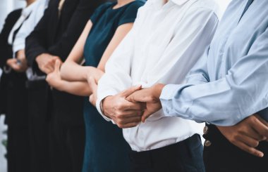 Mutlu ve gülümseyen çok ırklı ofis çalışanı, sinerjiyi ve ticari başarı için işbirliğini destekleyen bir kuyrukta el ele tutuşuyor. Modern işyerinde çeşitli profesyonel ofis çalışanları arasında bağ var. Uyum